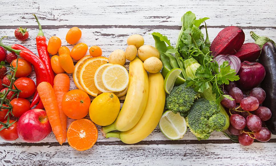 rainbow of fresh fruits and vegetables on white counter